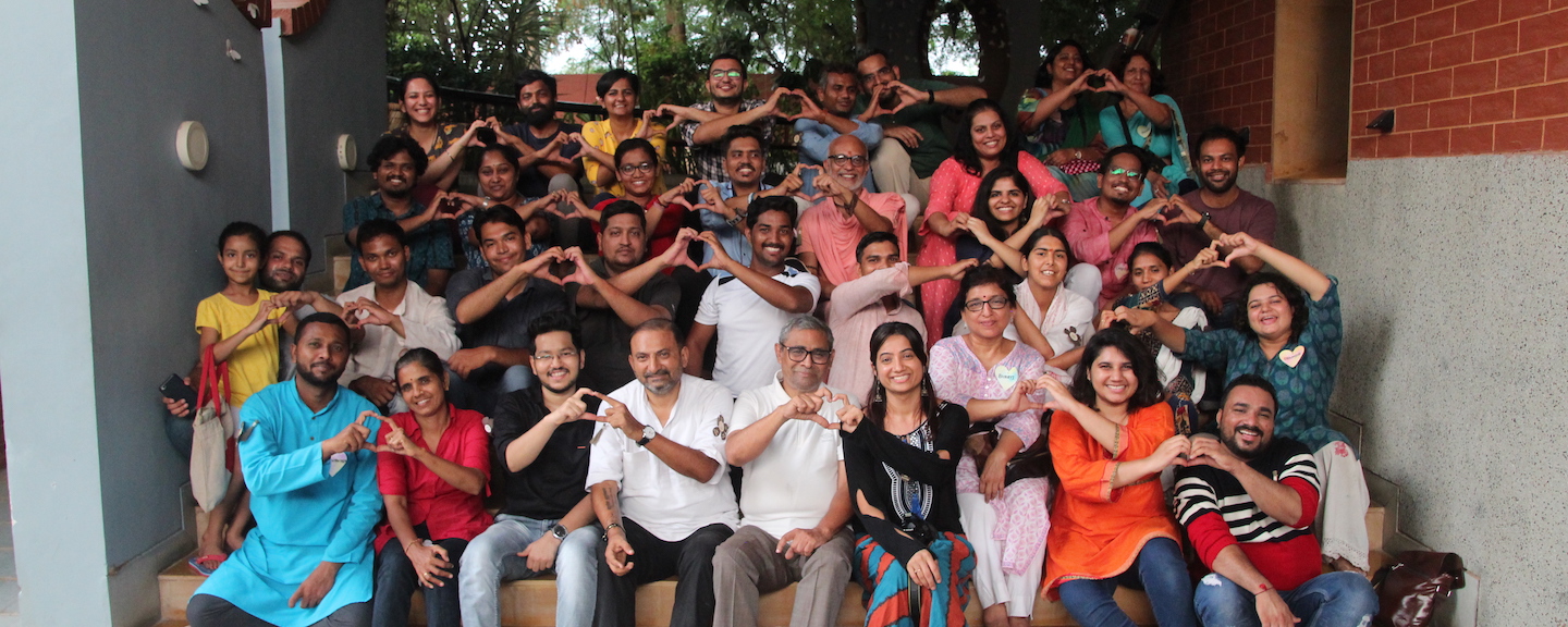People gathered together, forming hearts with their hands