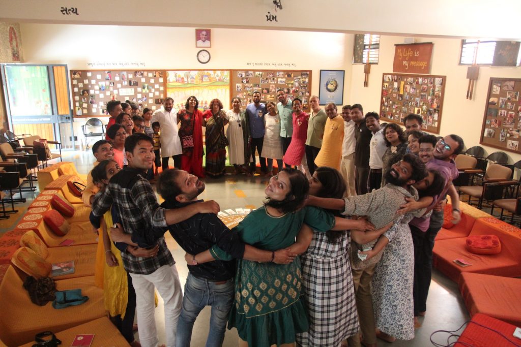Adults standing together in a circle at a Love Heals Cancer community gathering